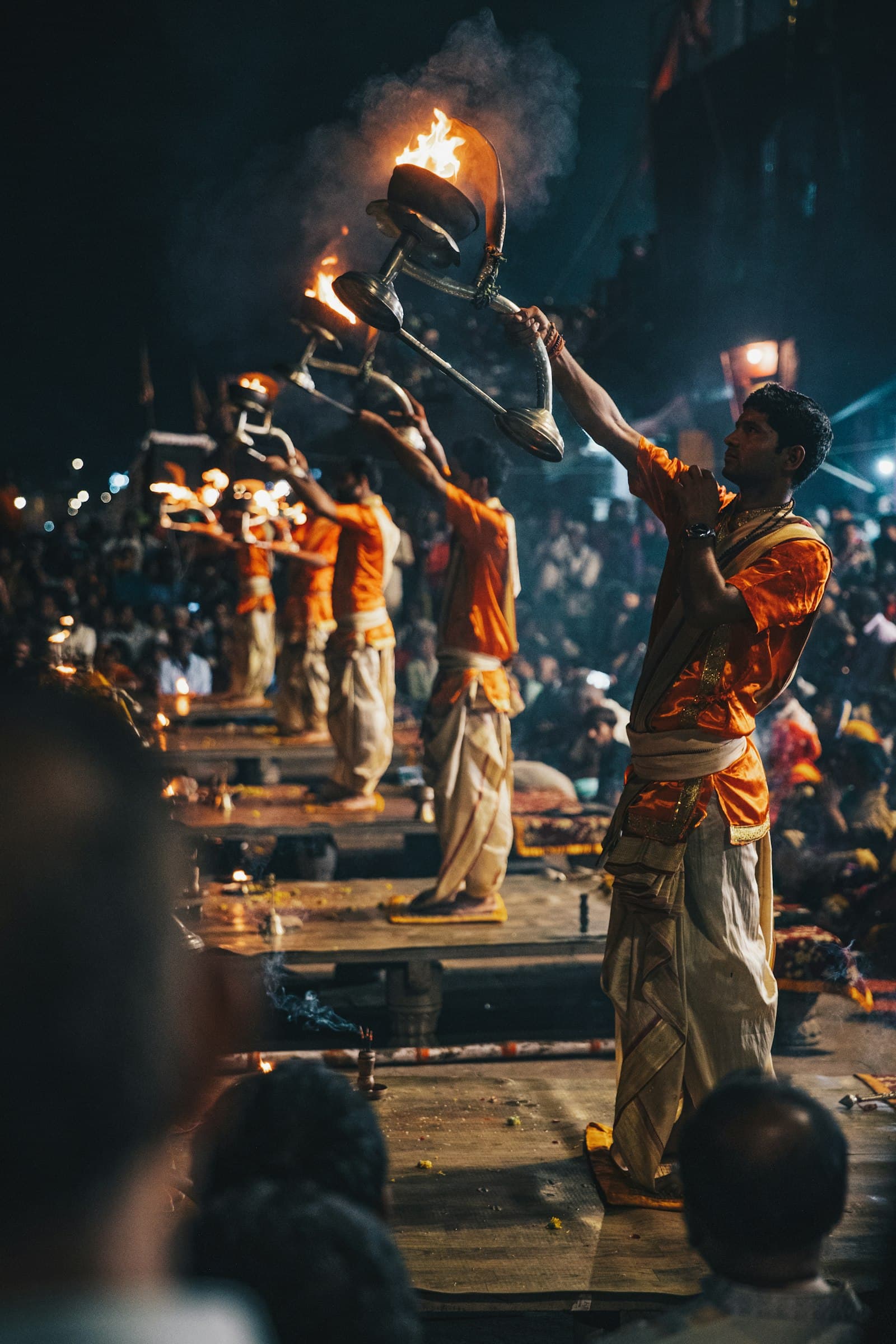 Priests raise tiered fire lamps during the evening Ganga aarti in Varanasi